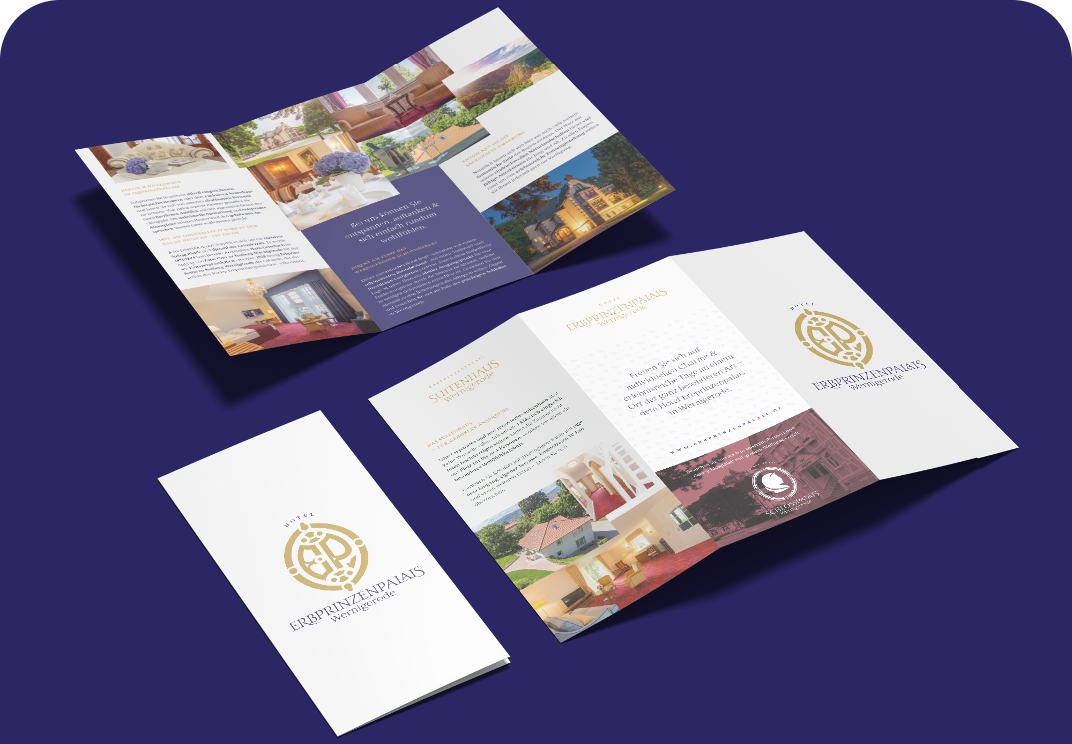 Zwei geöffnete Broschüren des Erbprinzenpalais Wernigerode zeigen Fotos der Hotelzimmer und des Gebäudes.