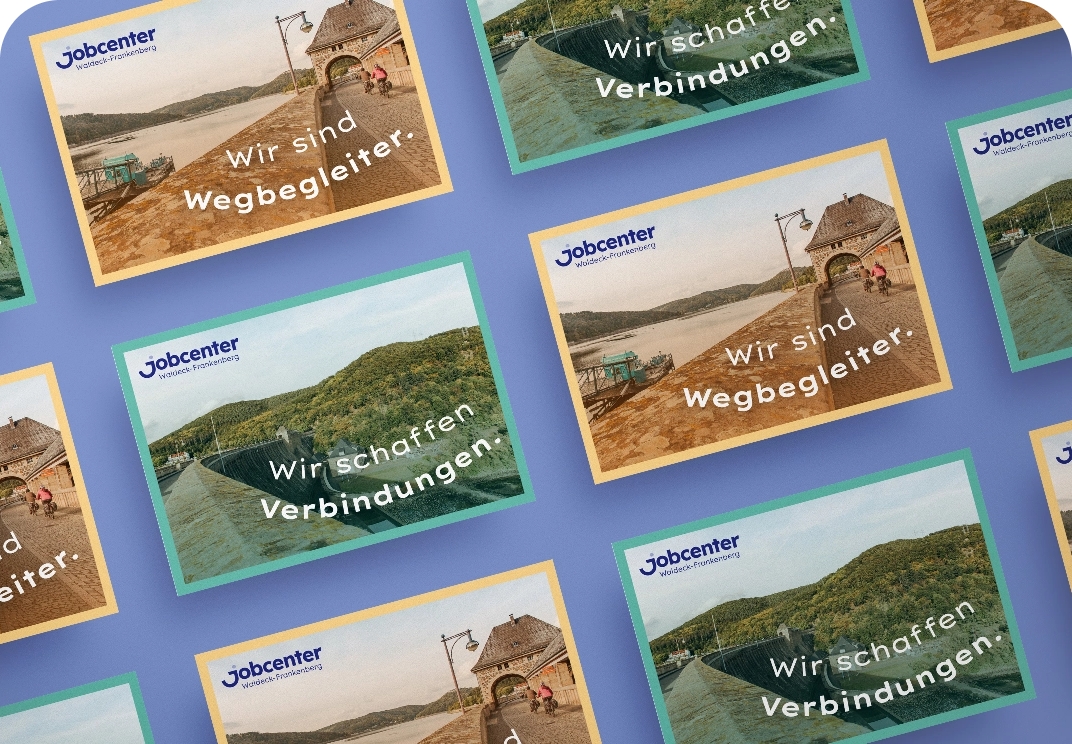 Mehrere Karten des Jobcenters Waldeck-Frankenberg liegen übereinander, darauf sind Fotos von Landschaften und