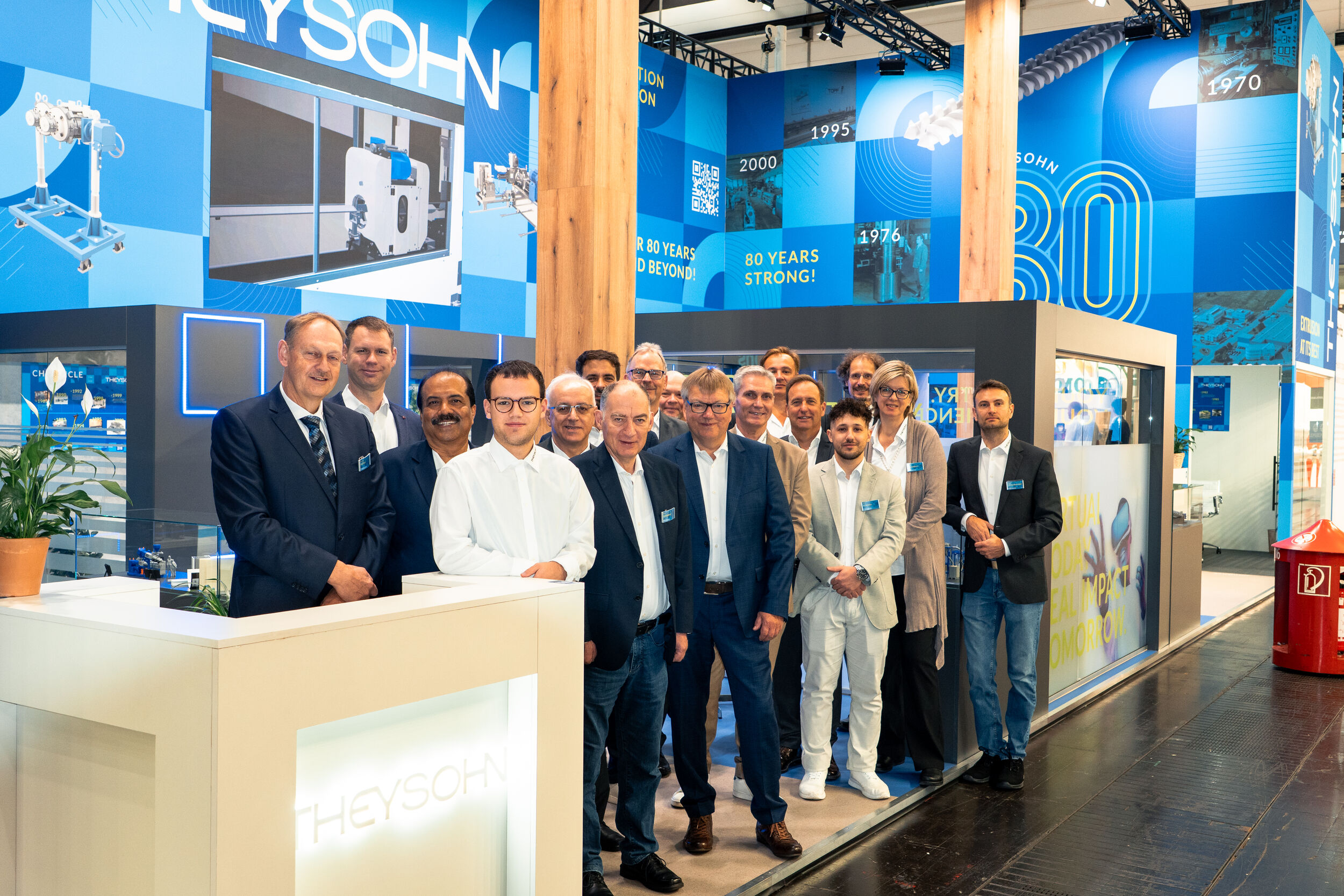 Belegschaft der Theysohn Extrusionstechnik GmbH vor ihrem Messestand